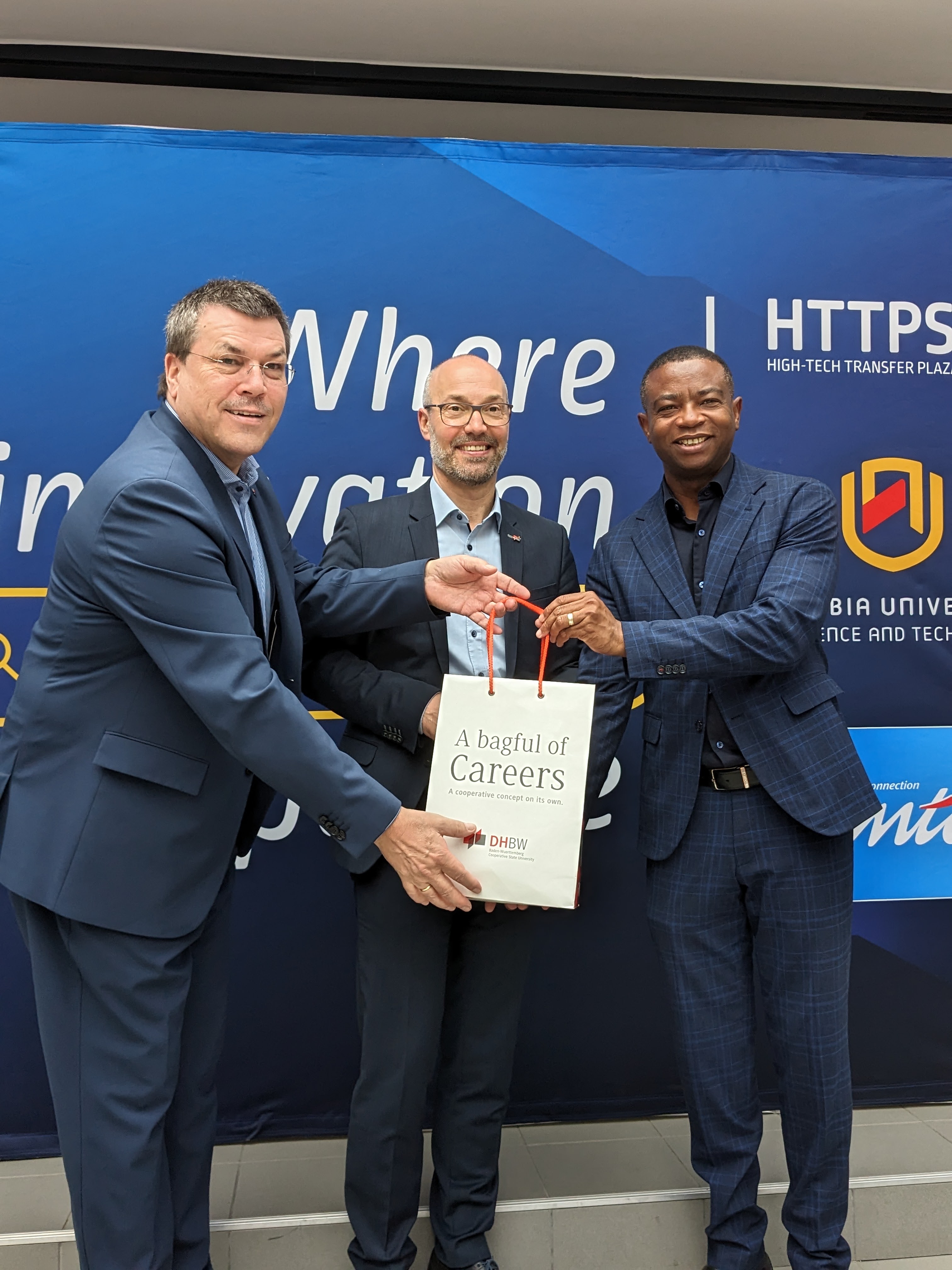 NUST Vice- Chancellor Dr Erold Naomab receiving a gift from Prof. Dr.-Ing. Herbert Dreher, President DHBW from  Ravensburg Campus (left)  and  Prof. Dr.-Ing. Stephan Schenkel, President DHBW from  Karlsruhe (right). 
