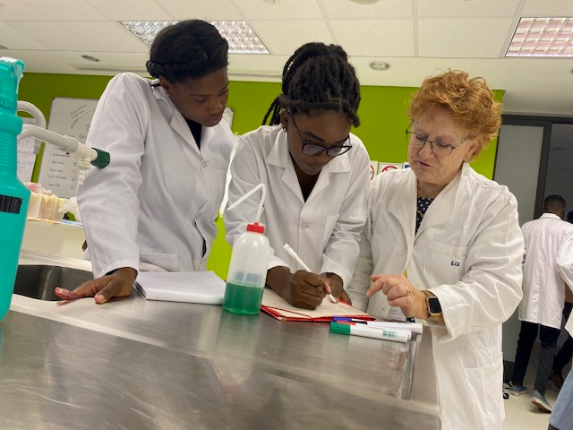 Dr Corinne Ganetenbein taking a moment to share insights with two students during a laboratory practical session