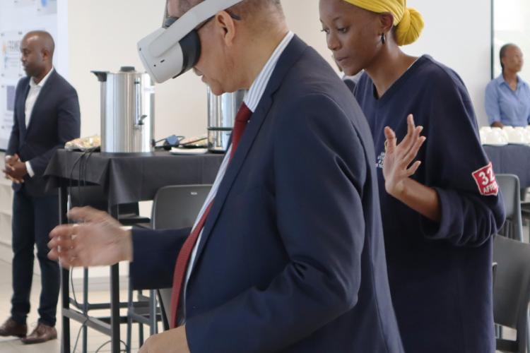 Deputy Executive Director for the Lifelong Learning Department from the Ministry of Education, Arts and Culture (left) enjoying a virtual reality experience guided by Selma Auala, a student from the Faculty of Computing and Informatics.