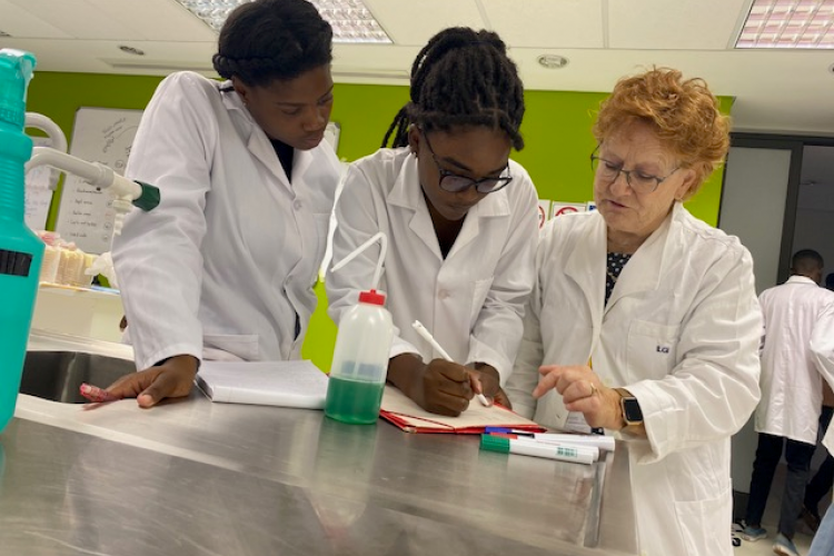 Dr Corinne Ganetenbein taking a moment to share insights with two students during a laboratory practical session